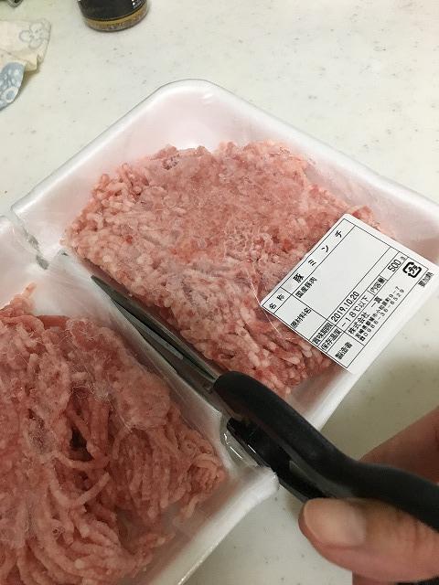 肉をトレイごと半分に切る